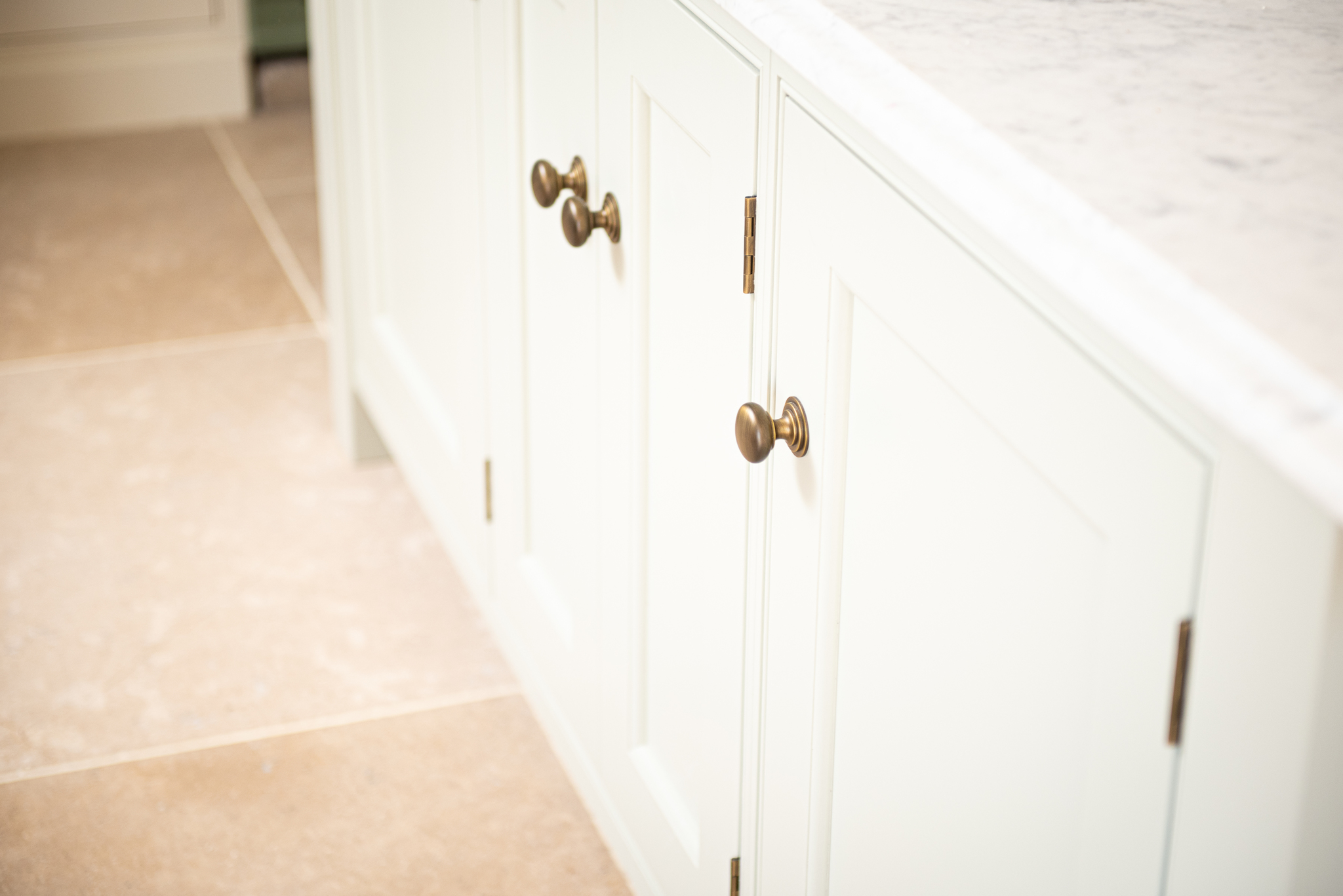 vintage provence limestone floor tile with white kitchen units